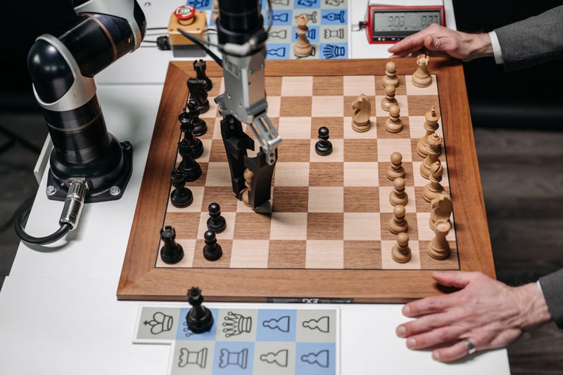 A robotic arm playing chess against a human hand